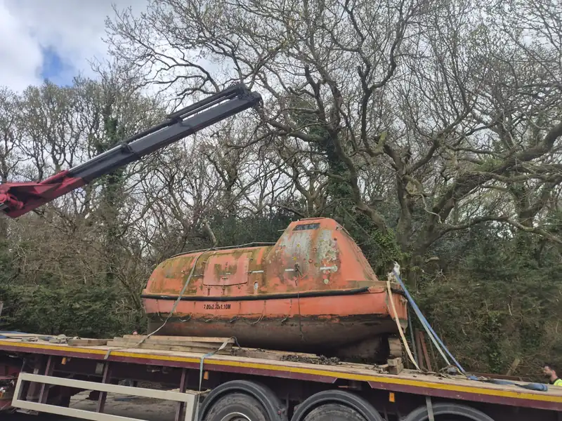 The lifeboat on a lorry beneath a crane