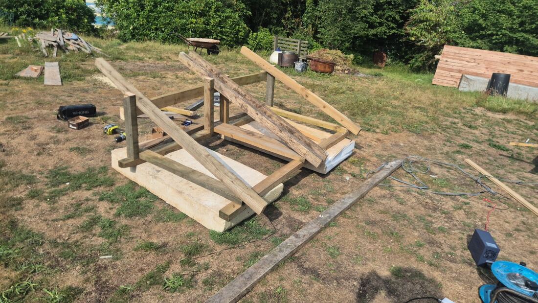 Timber frame of the solar oxygenator being assembled on grass