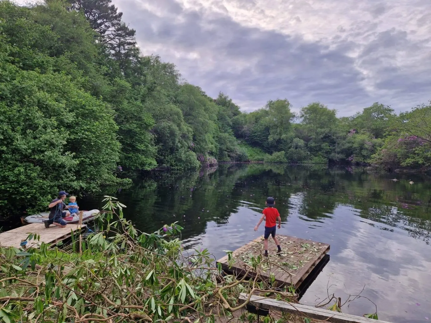 Family spending time on the pontoons beside the wooded lake
